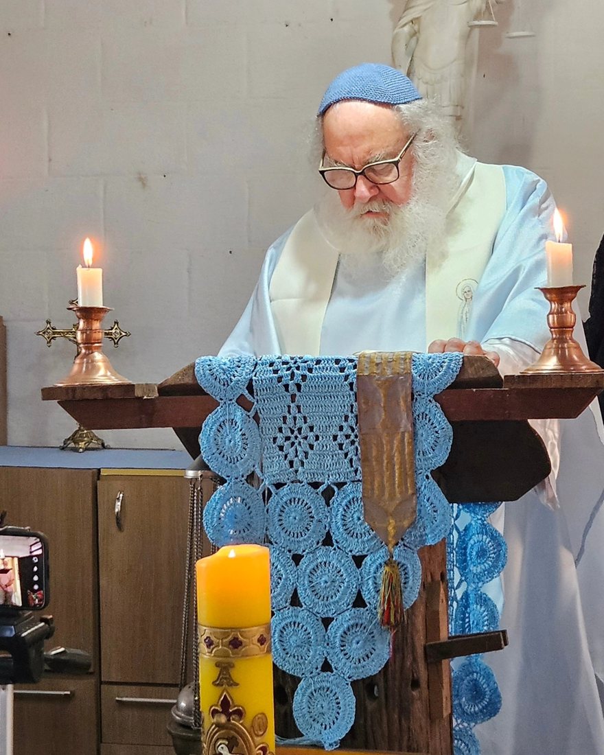 Irmão Bernardo da Esperança diante do ambão, em vestes claras, durante a celebração